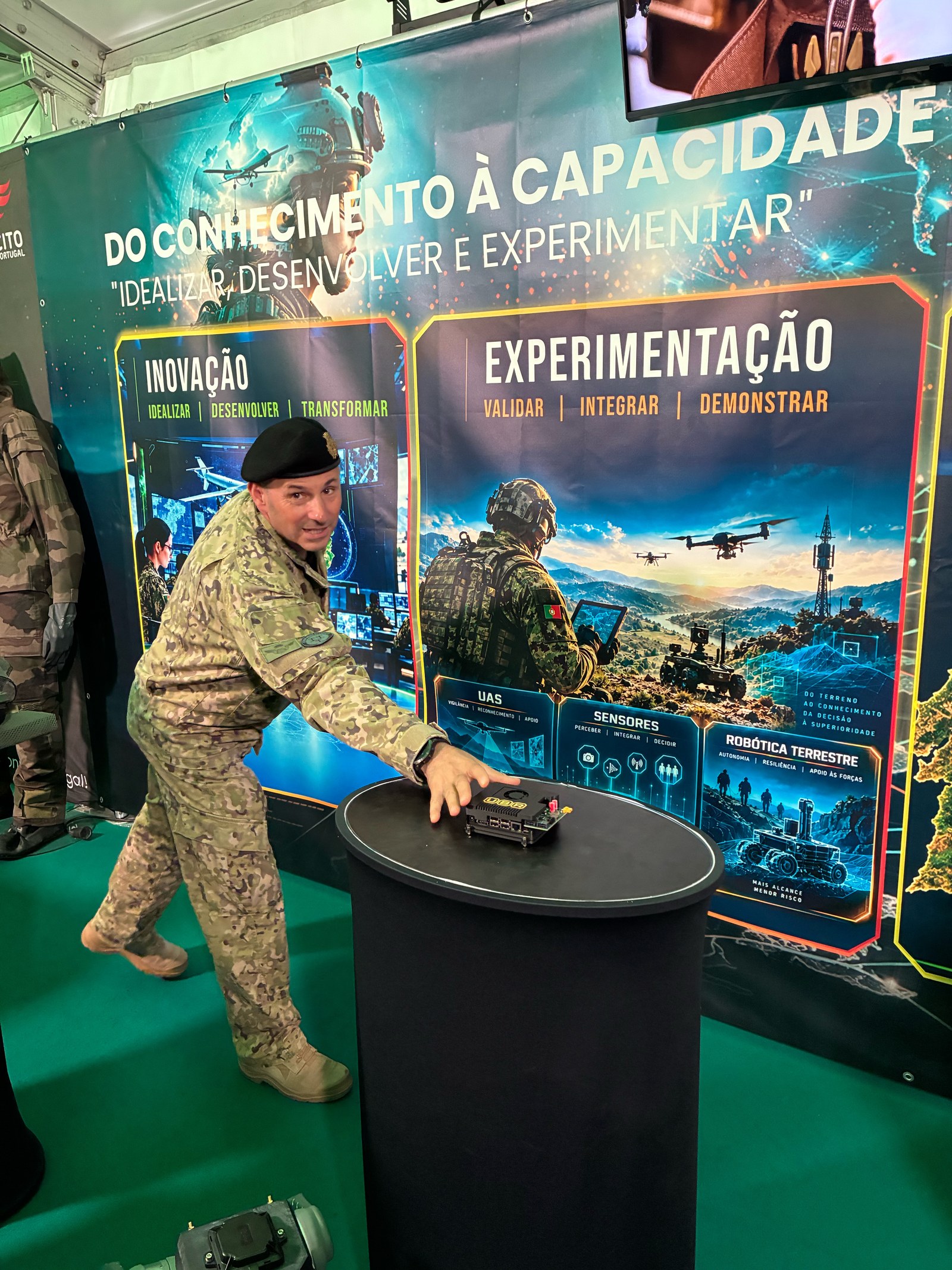 Portuguese Army officer inspecting the UBR Brain module on the pedestal in front of the Exército innovation banner