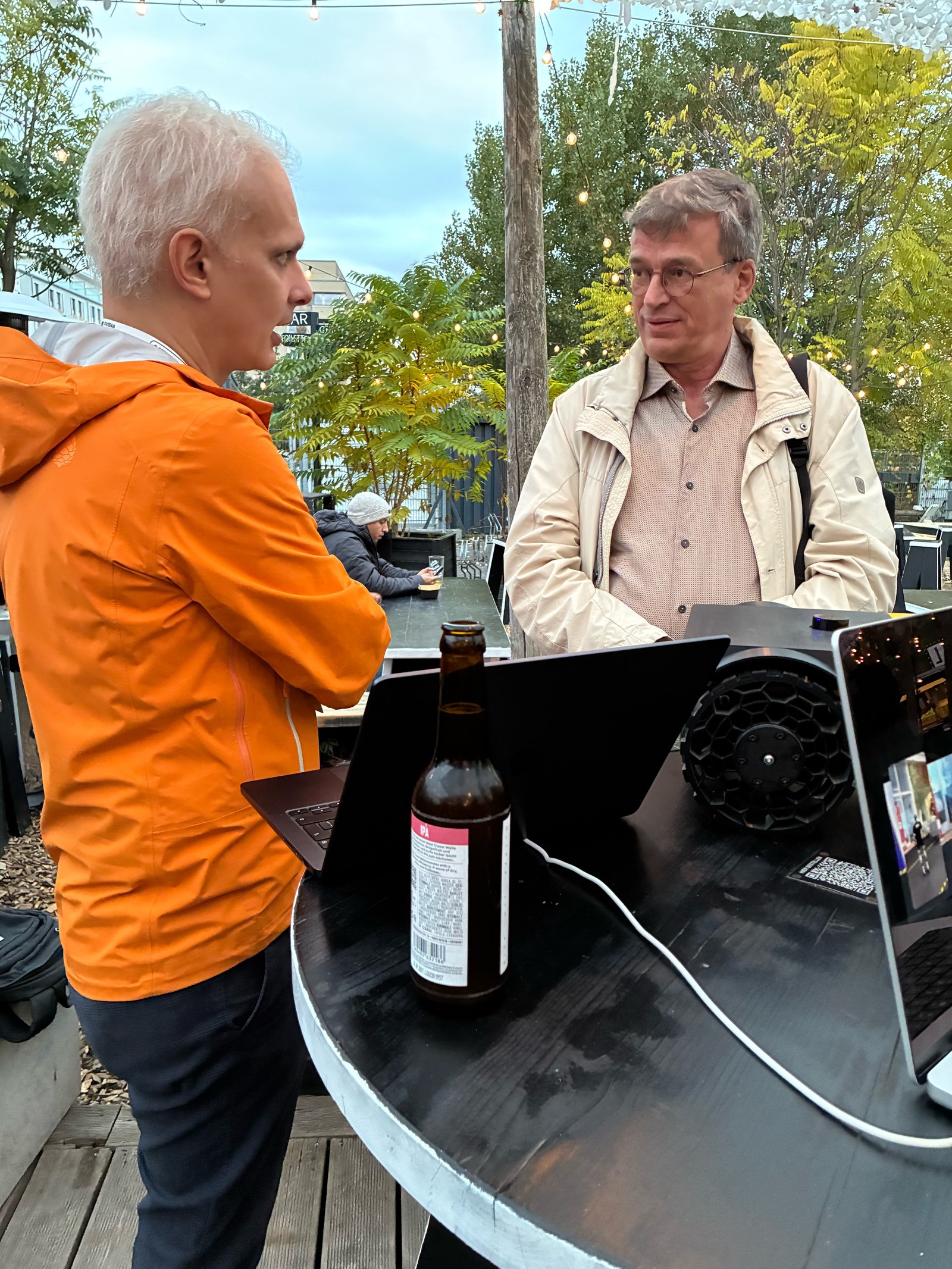 Francisco talking with an attendee outdoors at BRLO with UBR-001 and the operator laptop on the table