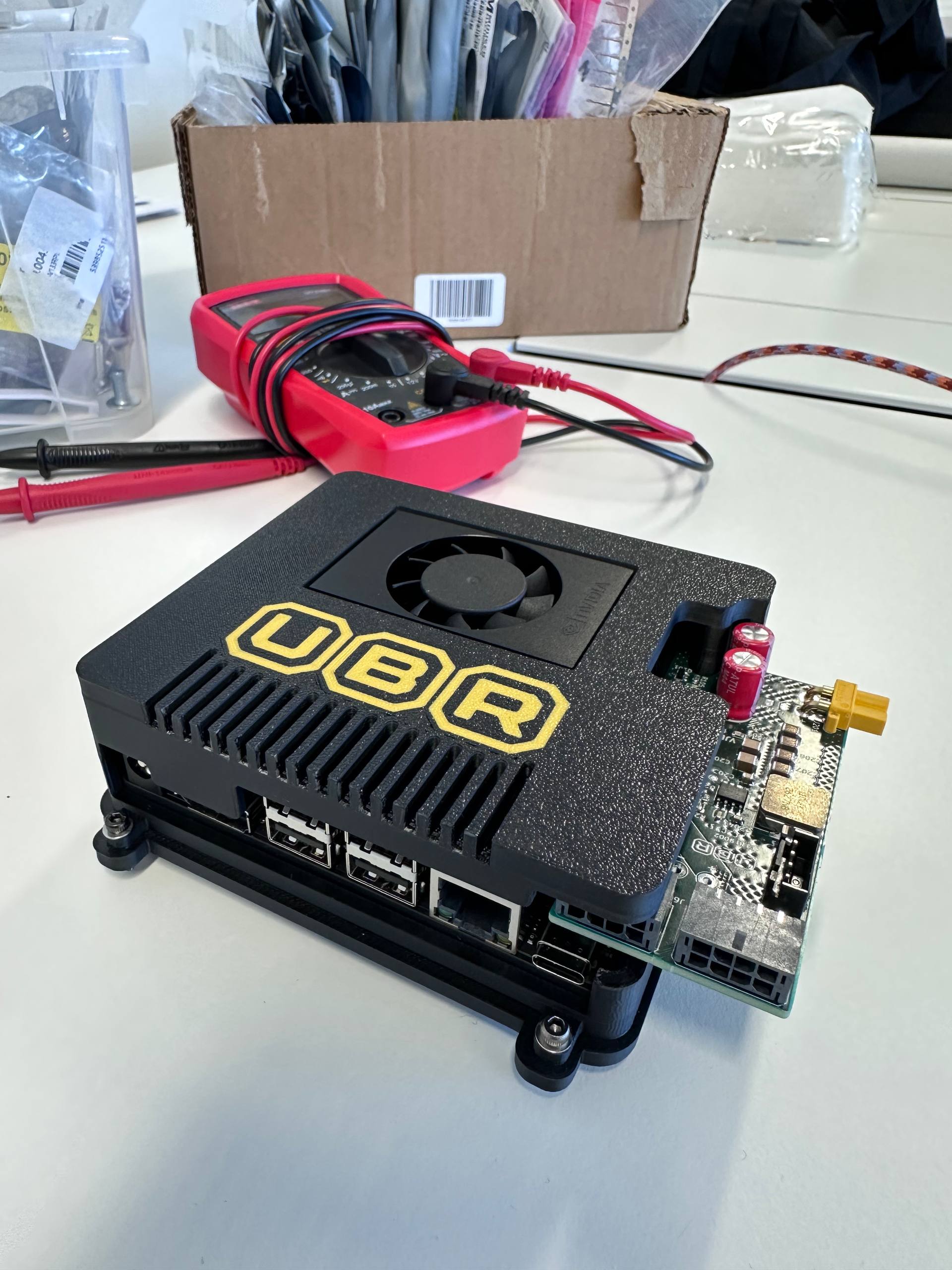 Close-up of the assembled UBR Brain on the workbench with the multimeter